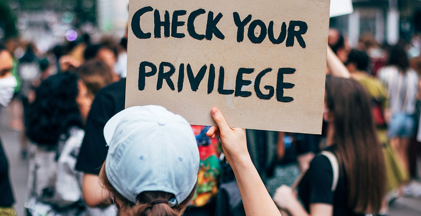 A woman holding a sign that reads 'Check you privilege' in black lives matter protest