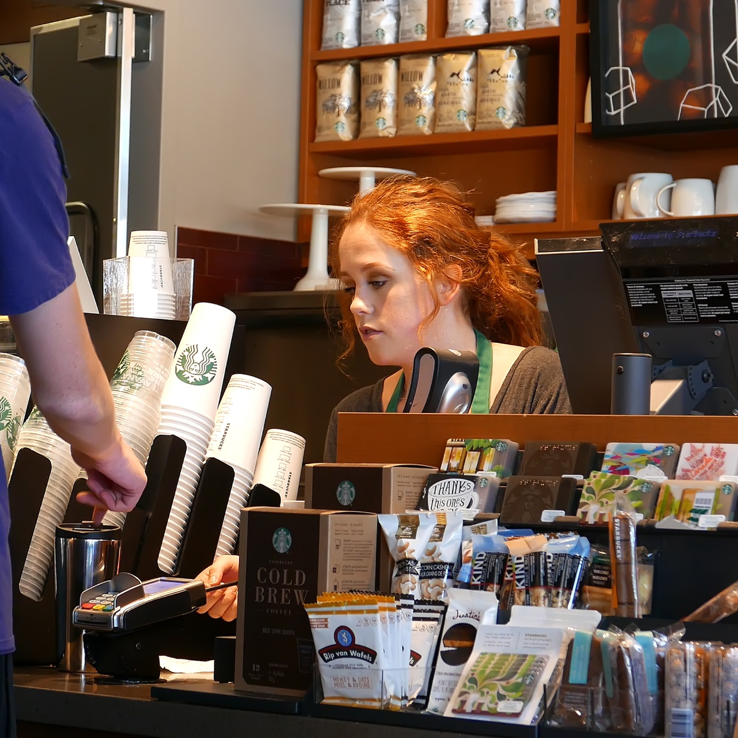  Close up man buying coffee and paying by credit card inside Starbucks store