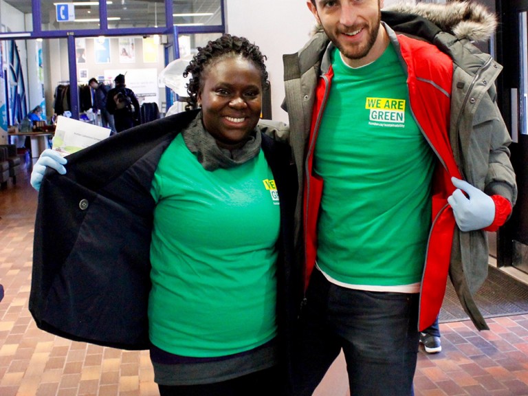 two volunteers posing showing off their green t-shirts