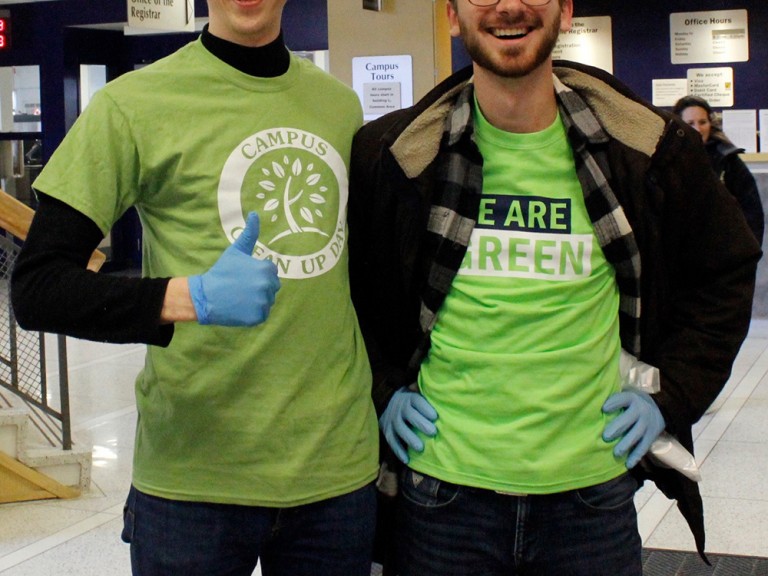two volunteers posing, one is giving a thumbs up