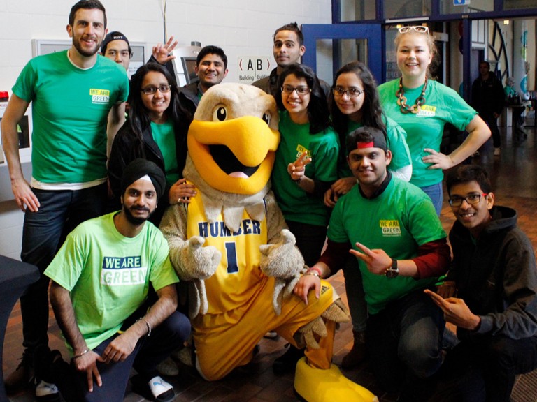 a group of volunteers posing with the humber hawk mascot