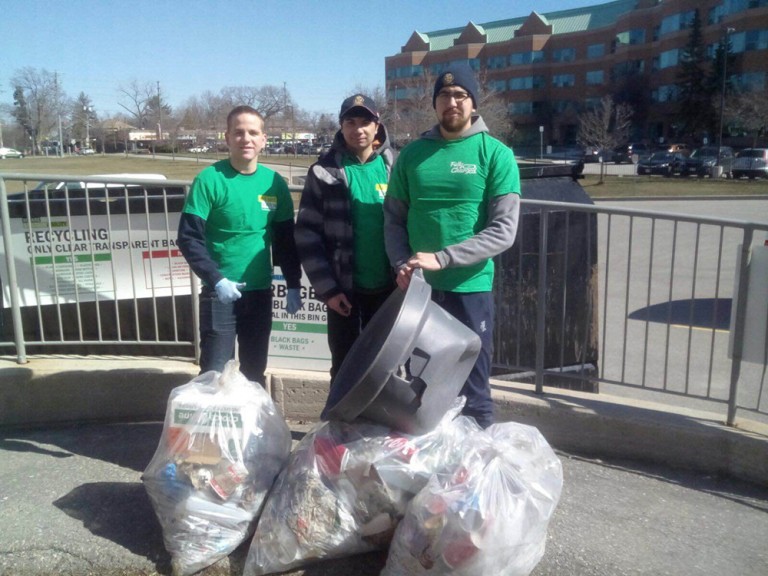 three volunteers by the trash they picked up.