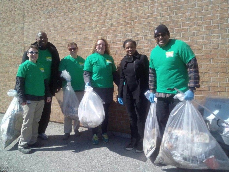 a group of 6 volunteers holding their trash bags