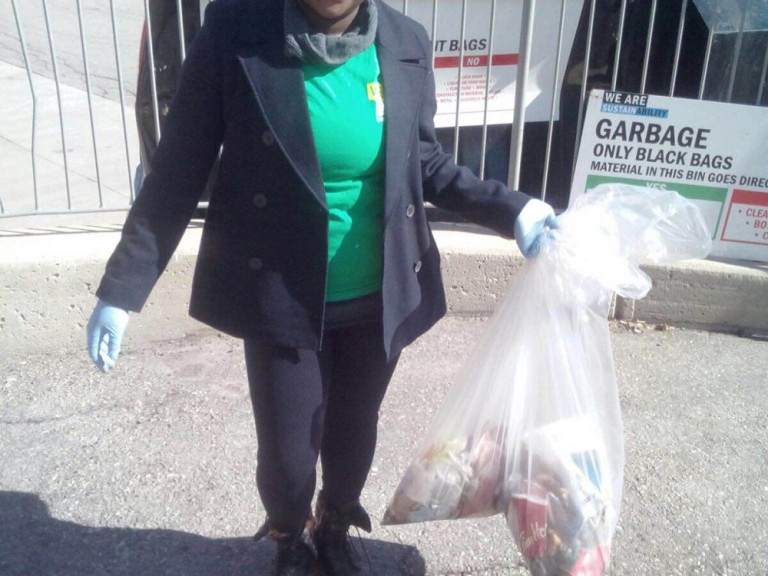 one volunteer holding her bag of collected trash