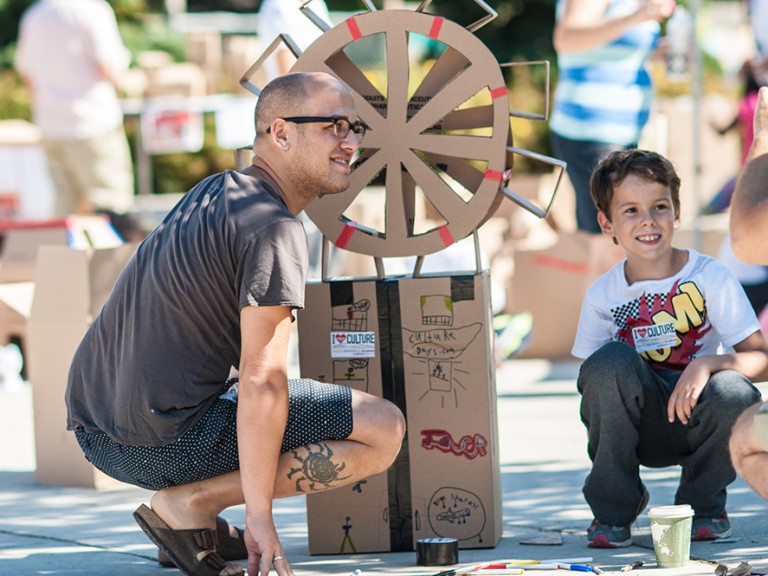 Man and child with a cardboard ferris wheel