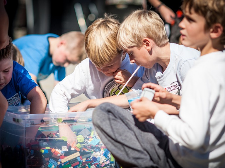 Kids reaching into a lego bin