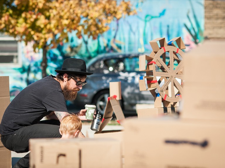 Man with child making cardboard crafts