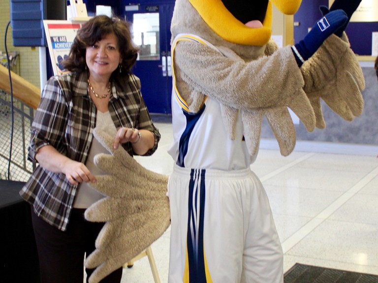 women holding the tail of the humber hawk mascot
