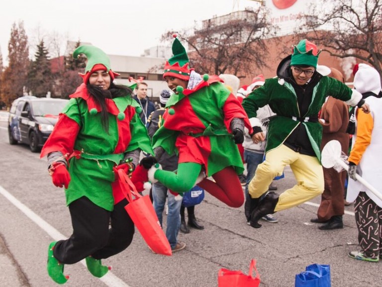 three people dressed in elf costumes jumping in the air