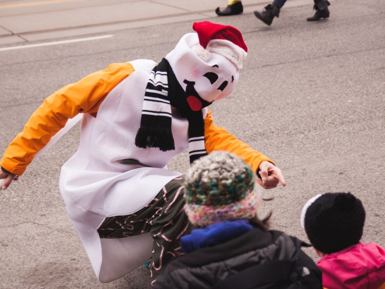 person in a snowman costume pointing to someone in the crowd
