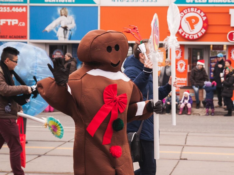 person in gingerbread man costume waving to the crowd