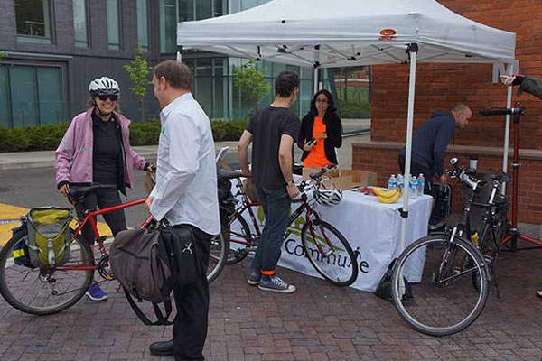 people standing at a booth with their bicycles