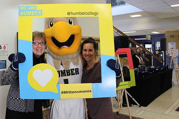 two people posing for a photo with the Humber mascot
