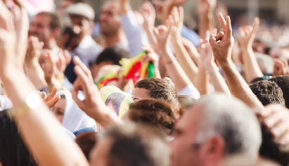 group of people waving their hands in the air