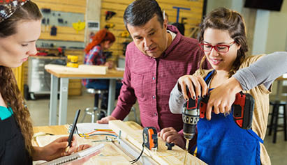 female student drilling holes in wood