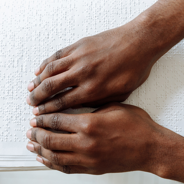 A braille book being read with two hands
