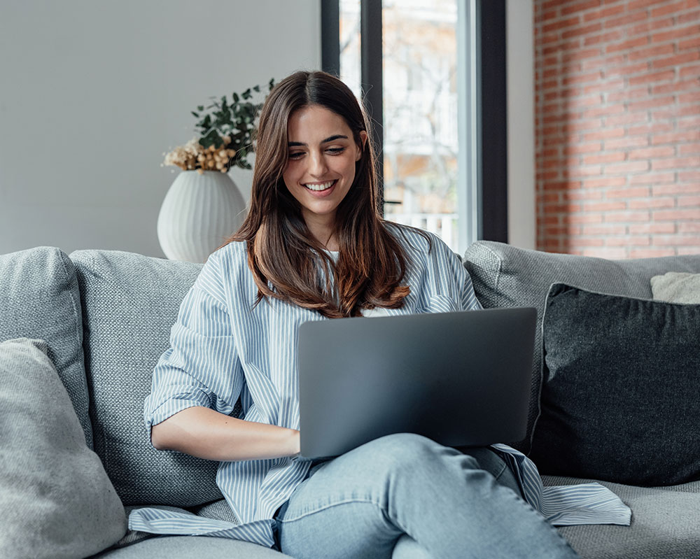 person sitting on a couch using a laptop