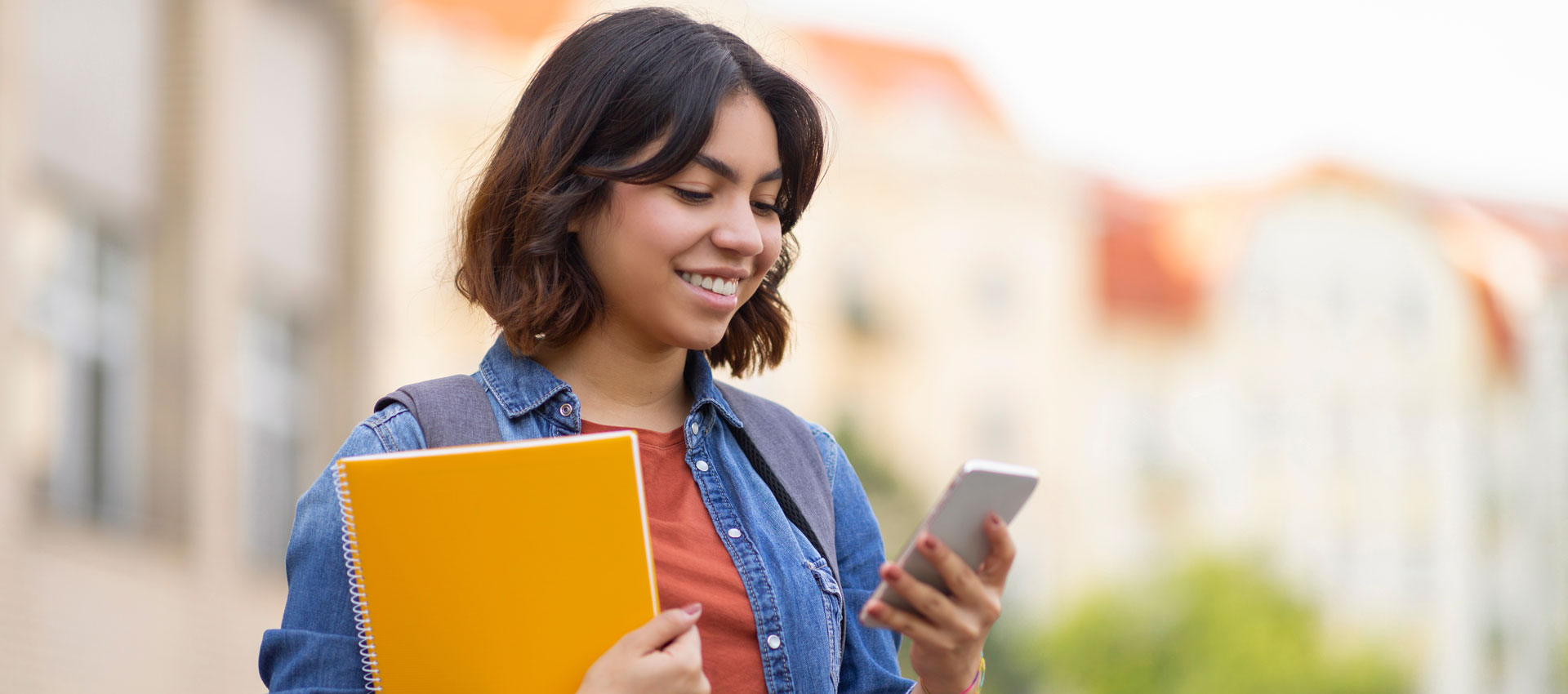 Smiling student holding mobile phone
