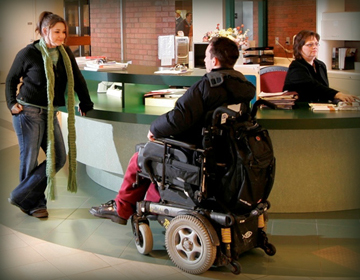 person standing talking to person in wheelchair