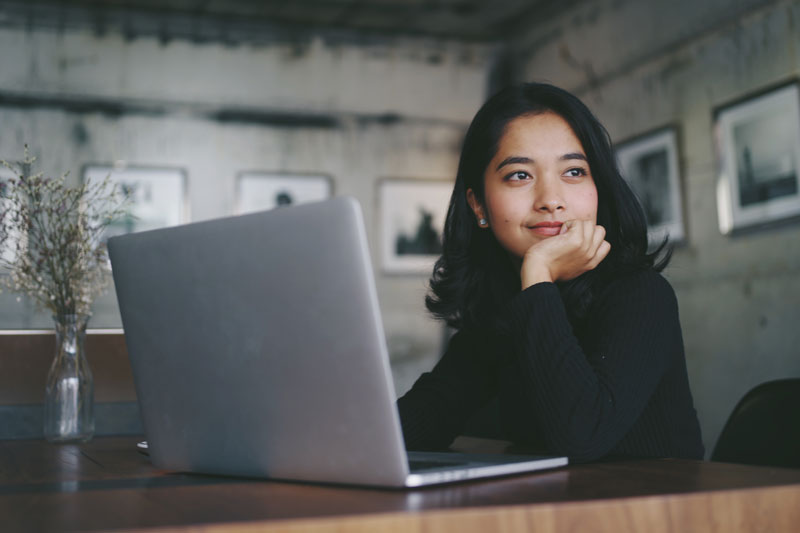 woman working at a desk with her computer