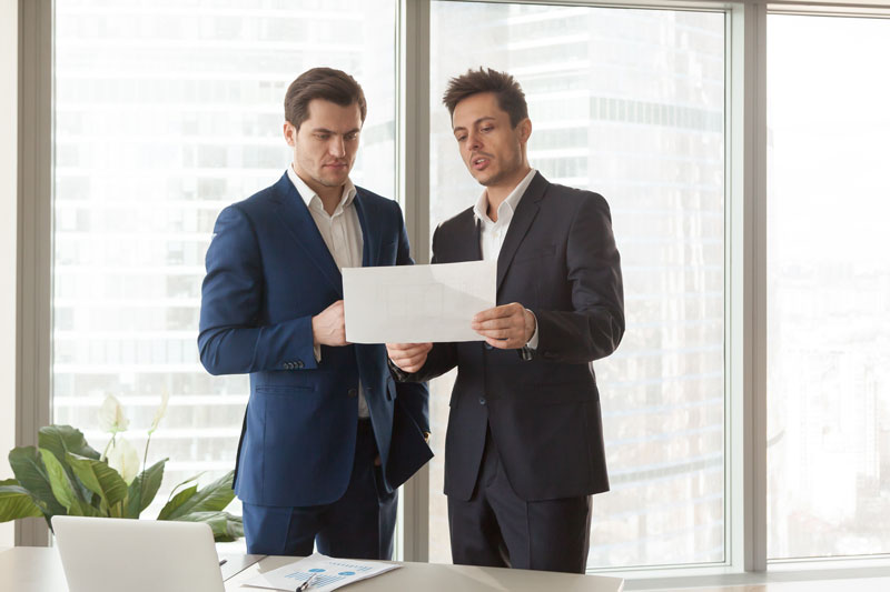 two brokers looking at a document
