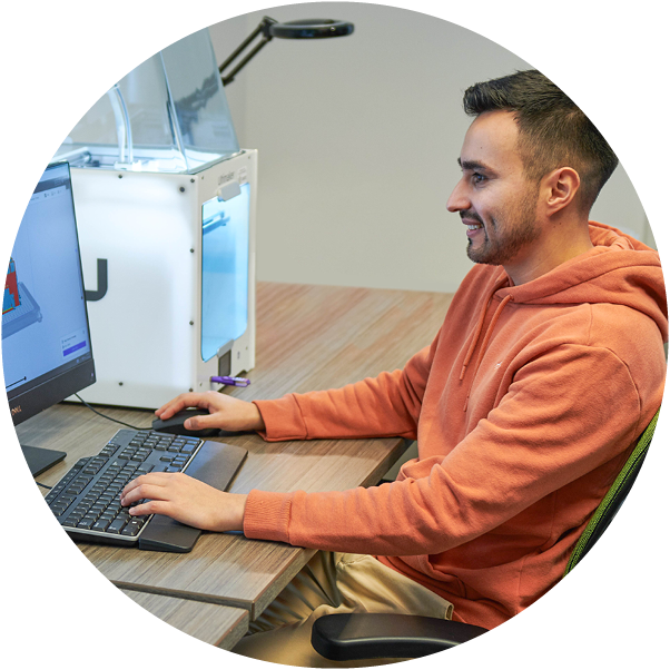 student sitting at a computer smiling