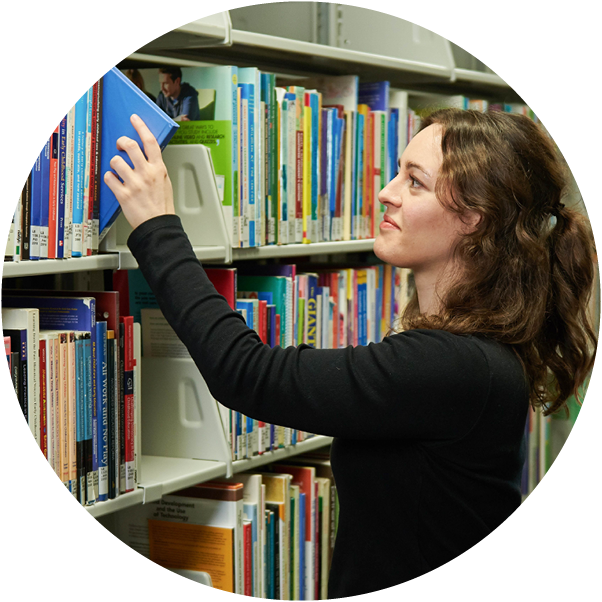 person putting a book back on a shelf