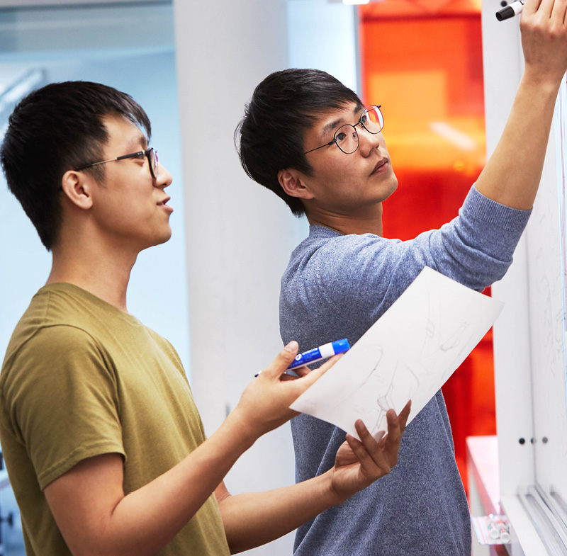 person writing items on whiteboard