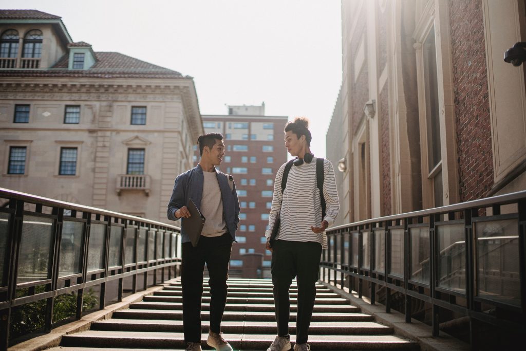 two people walking down stairs outside in a city