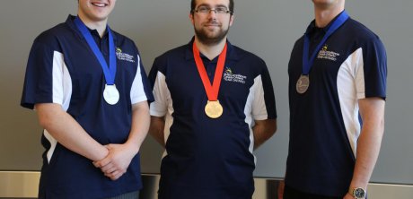 Three students with competition medals