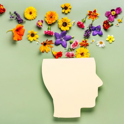 Concept image of well-being and mental health: flowers coming out of a face silhouette