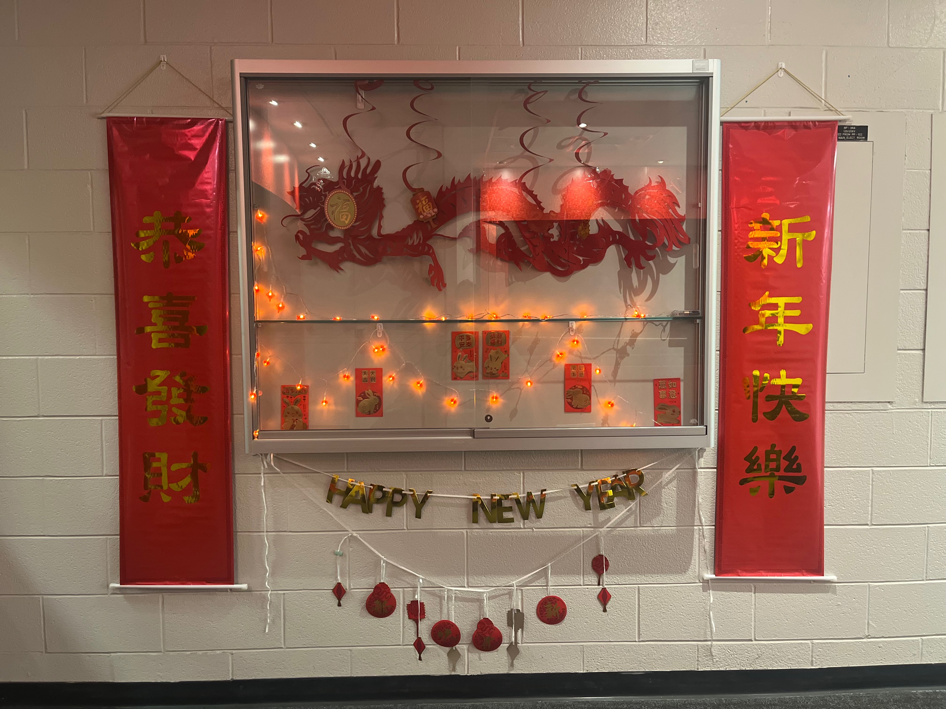 Lunar new year decorations behind a glass case on a wall