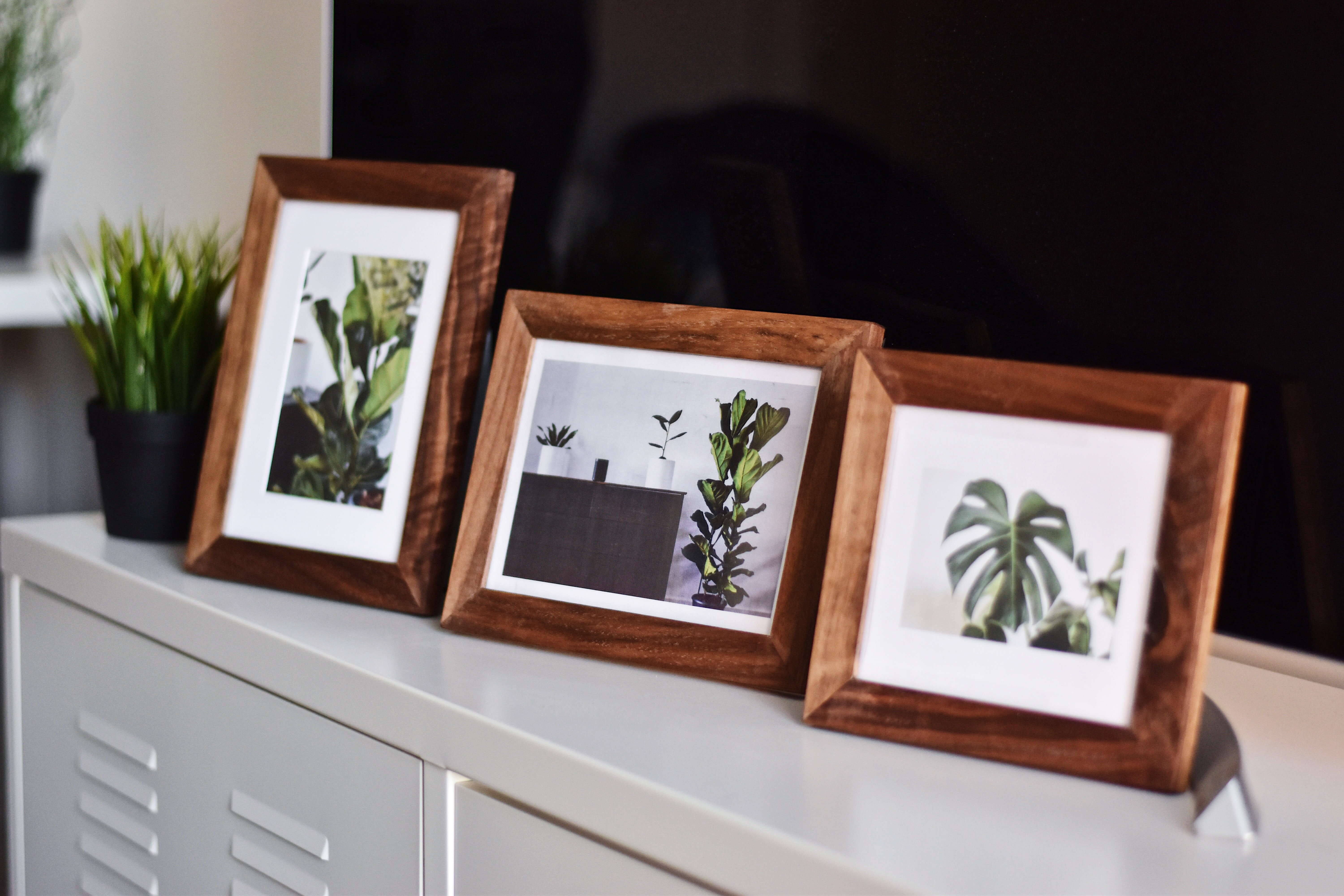 Three picture frames on a table.