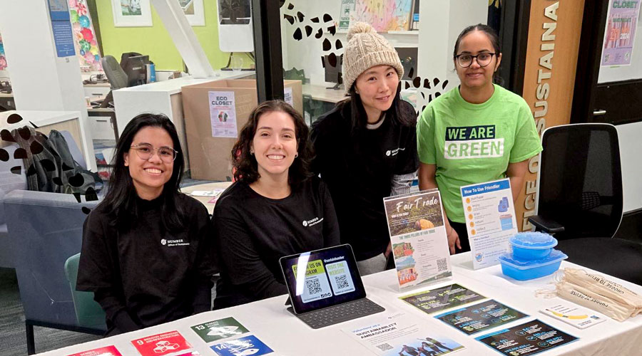 Four people at table in front of Sustainability office