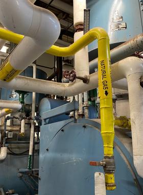 Yellow pipe labeled natural gas leading to a boiler