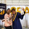 Elmena Walton and her daughter Carole pose joyfully with Carole's diploma and flowers. They are elated.
