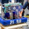 Students push a robot that has the number 2198 on it.