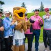 Several people wearing golf attire give a thumb’s up. Standing with them is the Humber Hawks mascot.