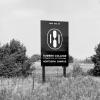 A black and white photo of the first Humber College logo on a billboard that reads New Site of Humber College Northern Campus.