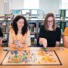 Four people are sitting at a table while playing a board game.