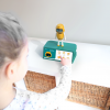 A child interacts with a small yellow and white Home Interactive and Virtual Exercise robot.