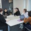 A group of people sitting around a table are having a discussion.