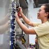 A person is using a tool to work on an electrical device.