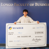 A person holds an oversized cheque in the amount of $5,000.