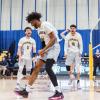 A player wearing a Humber Hawks jersey celebrates with their teammates on the court.