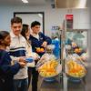 Students wait in line for food in a cafeteria.