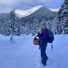 A person stands outside in a snowy forest.