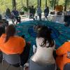 People sit in a circle while having a discussion.