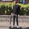 Henry Boy rides his project, Vagabond, which looks like a black electric scooter. He's sideways like on a skateboard