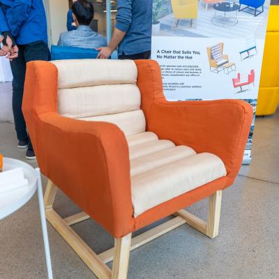 An orange chair with biege cushion running up the middle of it.